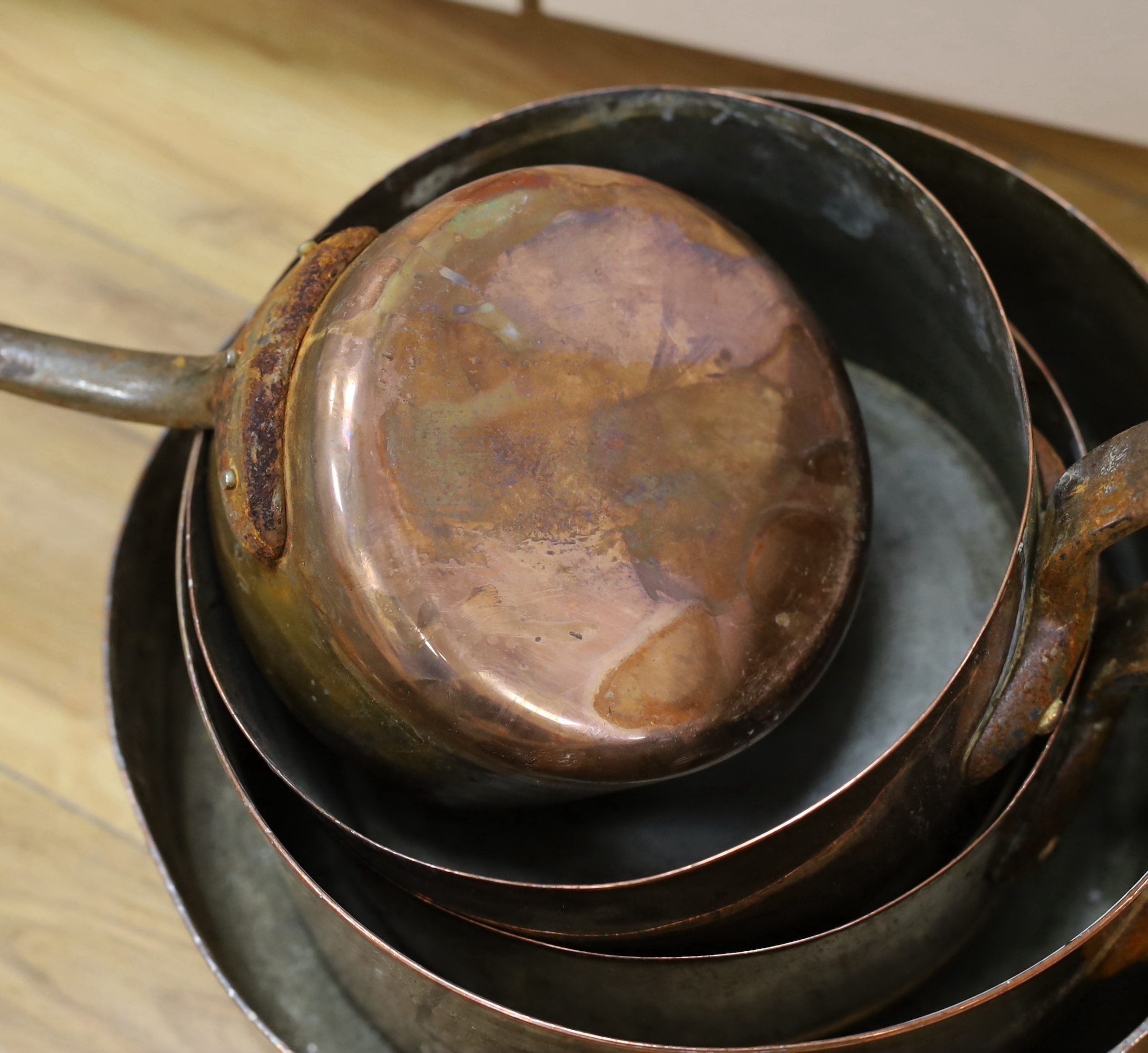 A set of five copper pans, largest diameter 28cm
